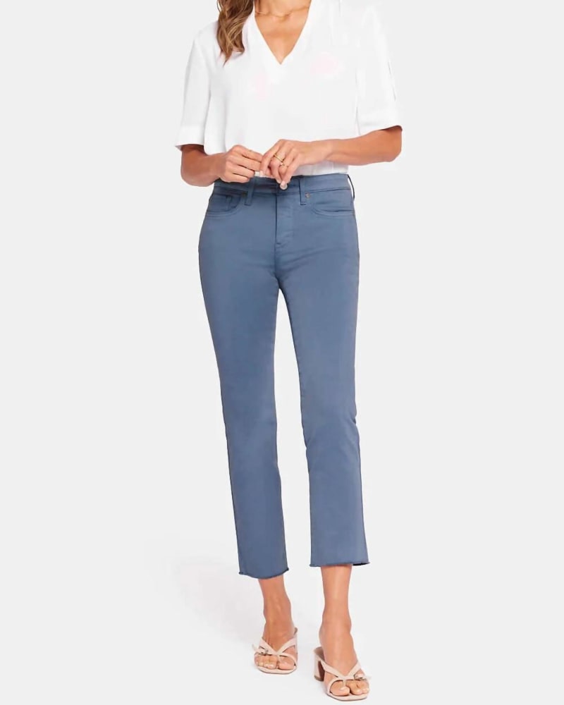 Front of a model wearing a size 10 Sheri Slim Ankle Jeans With Frayed Hems In Blue Stone in Blue Stone by NYDJ. | dia_product_style_image_id:355551